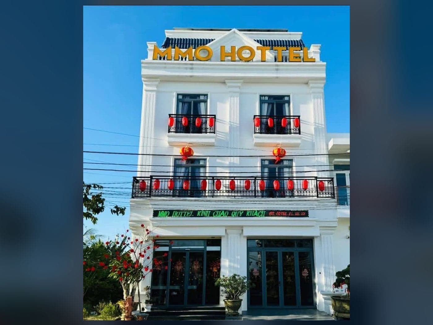 Mặt tiền khách sạn MMO HOTTEL, toà nhà trắng ba tầng có biển hiệu vàng