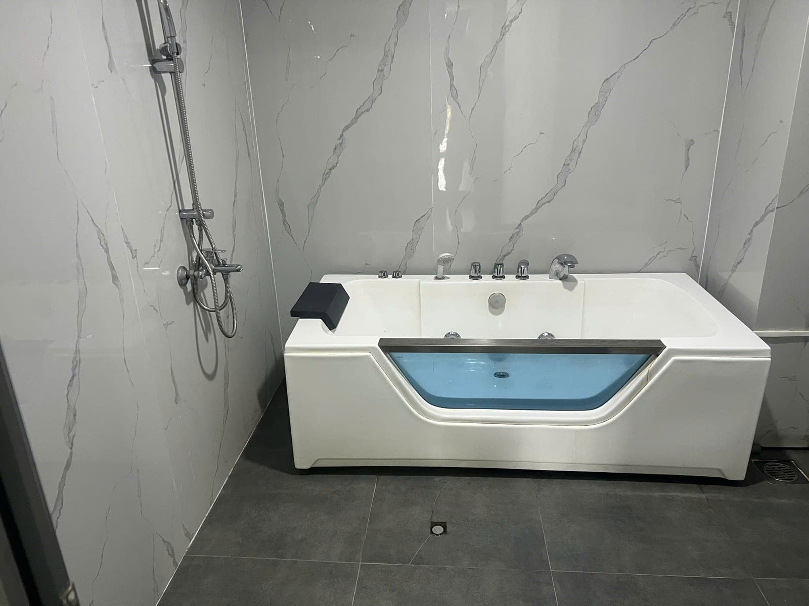 Nhà vệ sinh phòng VIP ốp đá, có bồn tắm massage và sen tắm