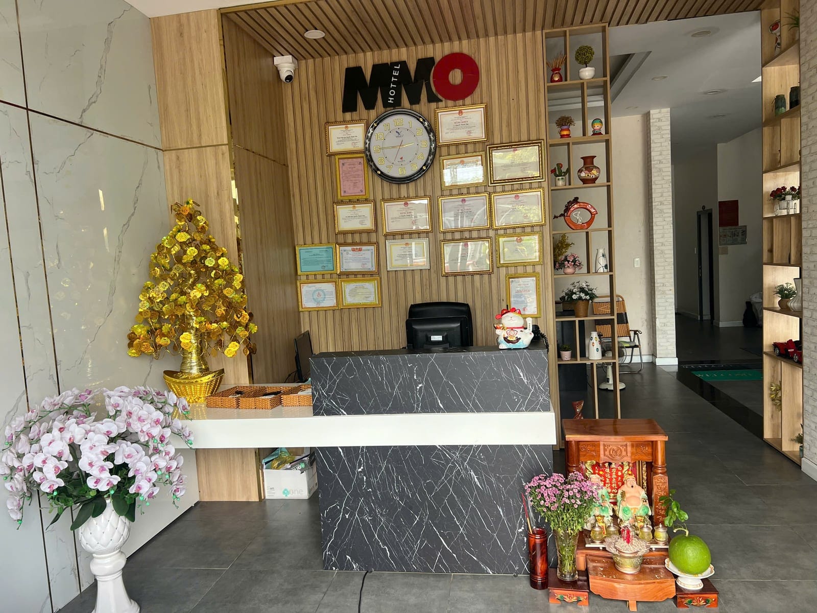 Quầy lễ tân MMO HOTEL với logo và tường bằng khen